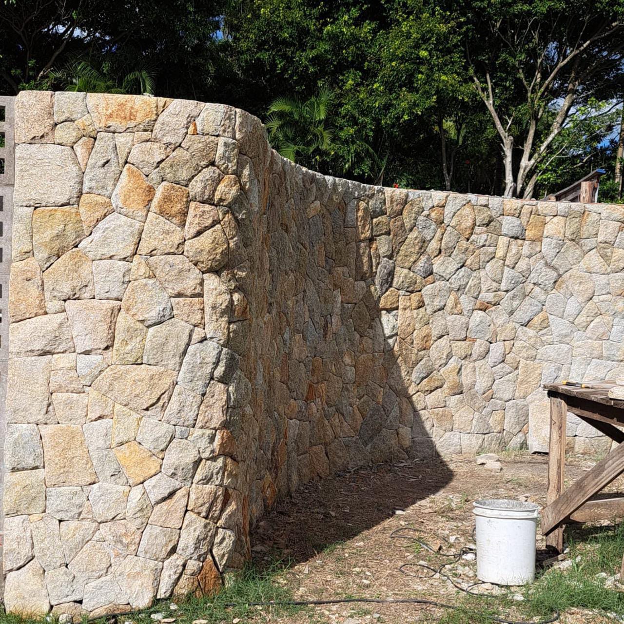 Muro curvo revestido em pedra